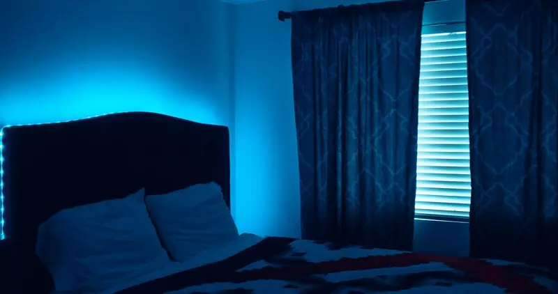 Đèn LED dây điểm nhấn màu xanh hắt sáng phía sau giường ngủ hiện đại