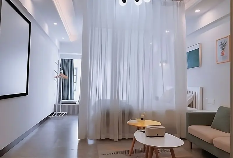 Vách ngăn bằng rèm vải mỏng màu trắng trong phòng khách, tạo sự mềm mại